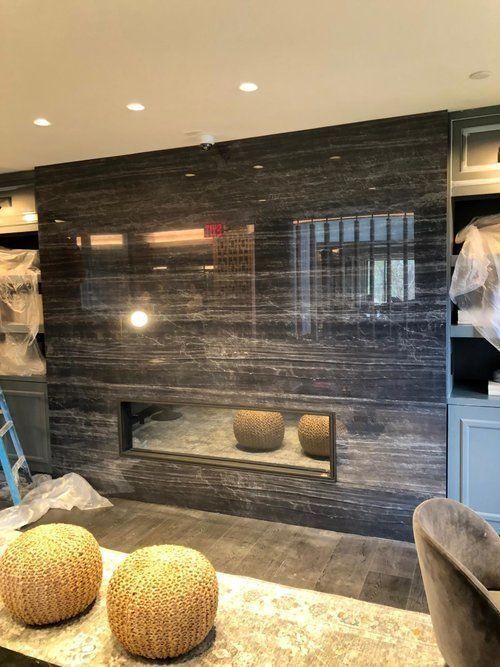 A living room with a fireplace and two ottomans