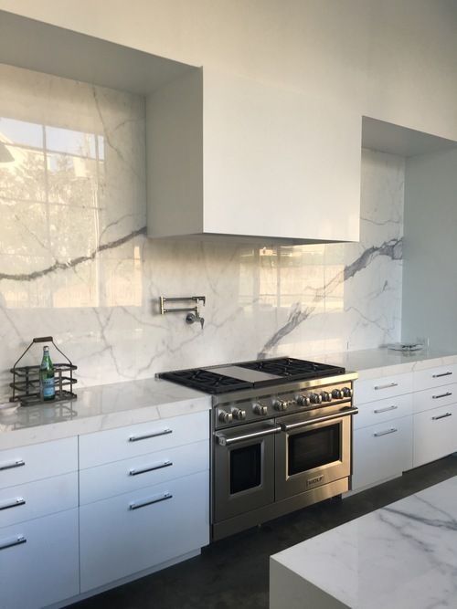 A kitchen with stainless steel appliances and white cabinets