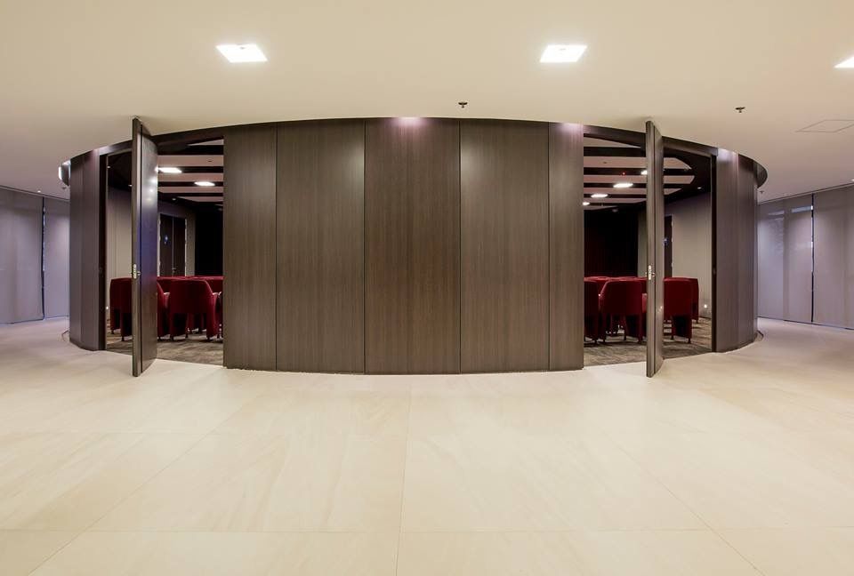 A large room with a round wall and tables and chairs in it