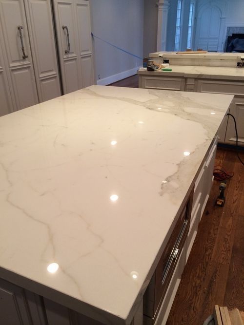 A kitchen with white cabinets and a large white counter top