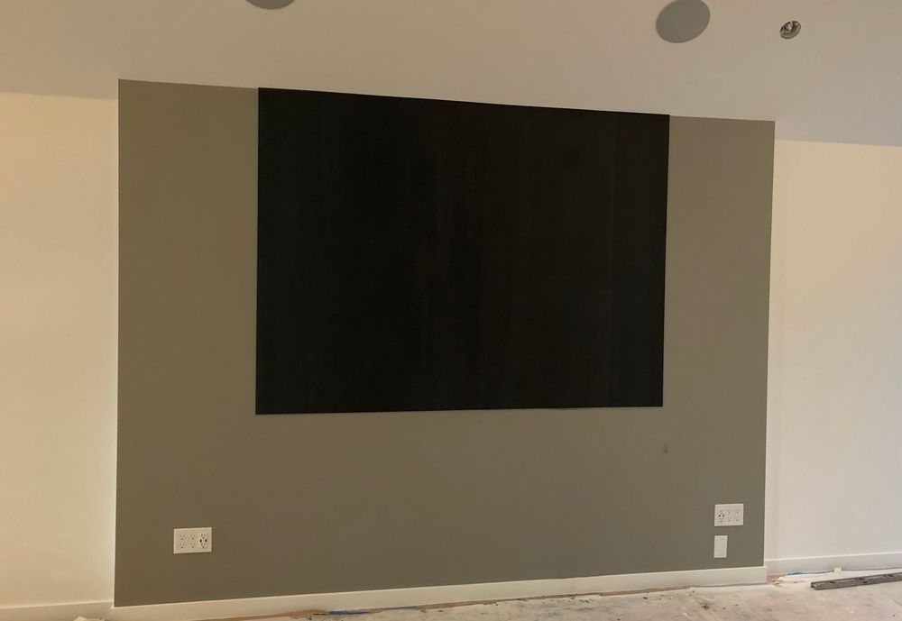 A large black screen is hanging on a wall in a room
