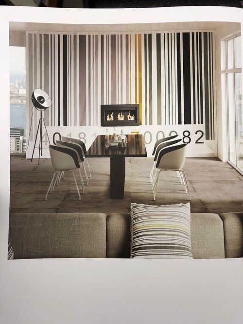 A living room with a striped wall and a table and chairs