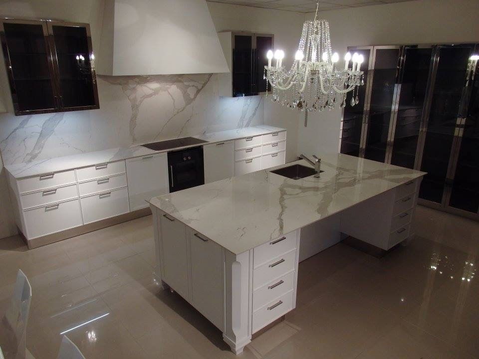 A kitchen with a large island and a chandelier hanging from the ceiling