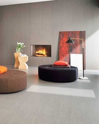 A living room with a fireplace and two ottomans