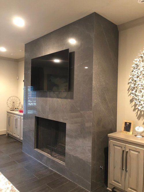 A living room with a fireplace and a flat screen tv on the wall