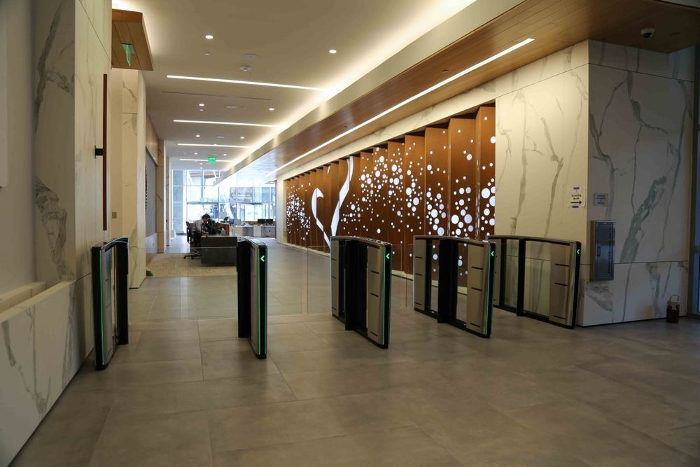 There are a lot of turnstiles in the lobby of a building