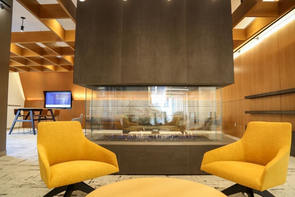 Two yellow chairs are sitting in front of a fireplace