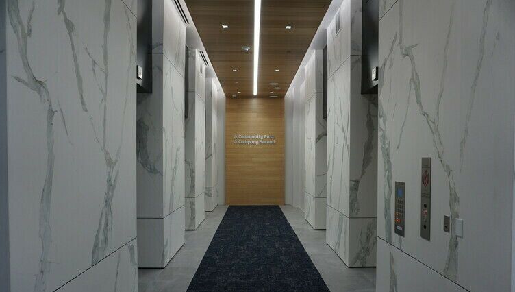 A long hallway in a building with a black carpet
