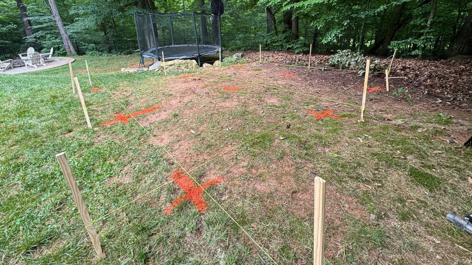 A fence is being built in the backyard of a house.