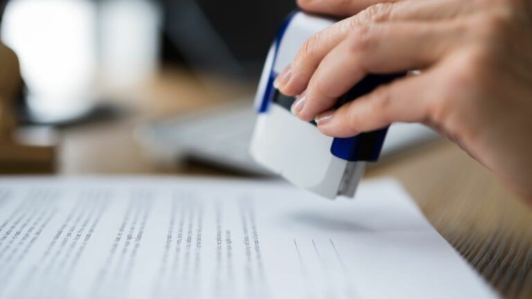 A person is stamping a piece of paper with a stamp.