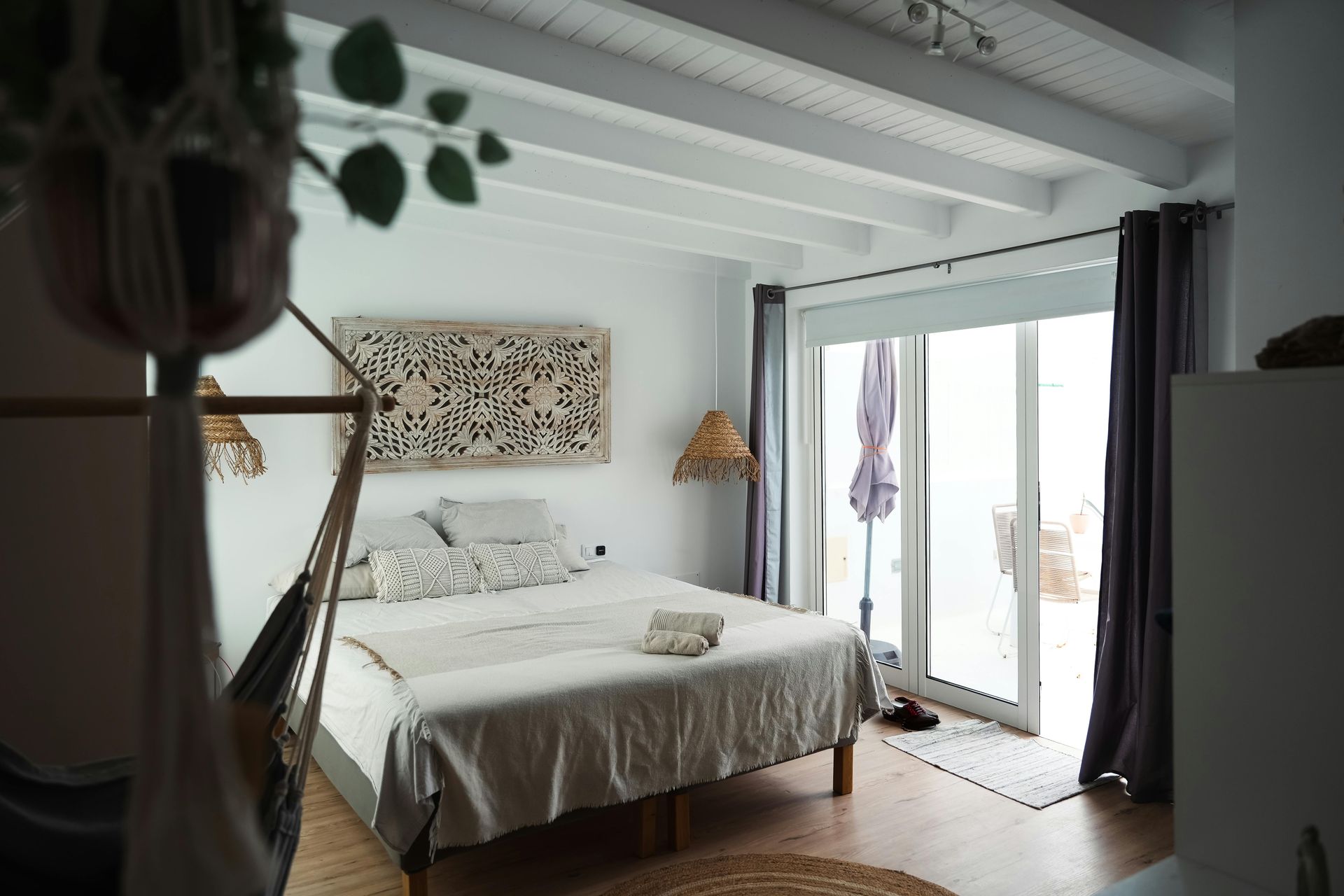 A bedroom with a large bed and a sliding glass door.