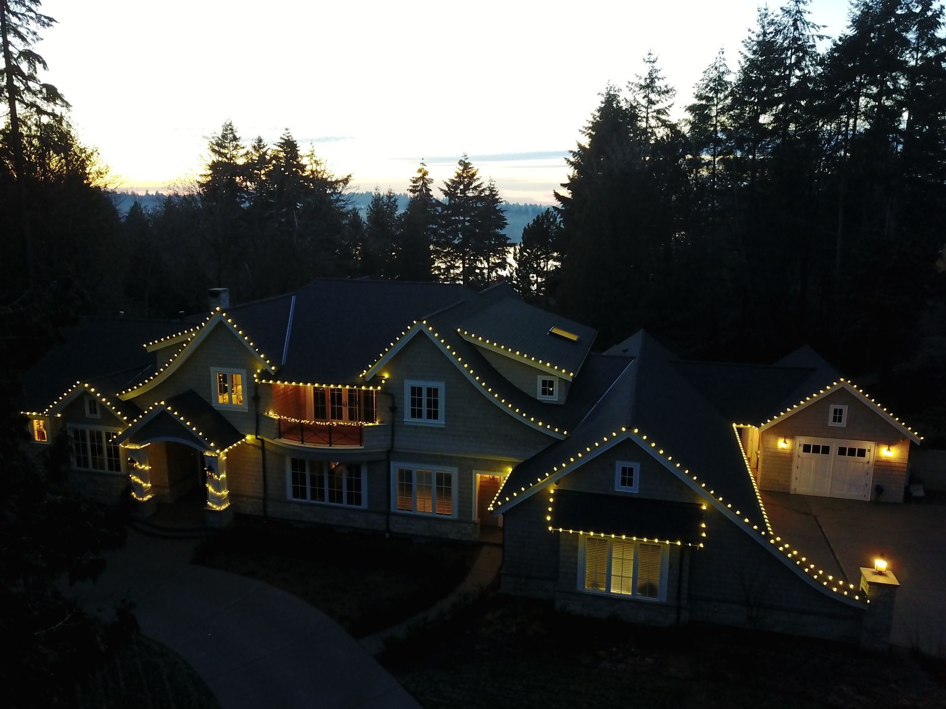 An aerial view of a house with christmas lights on it