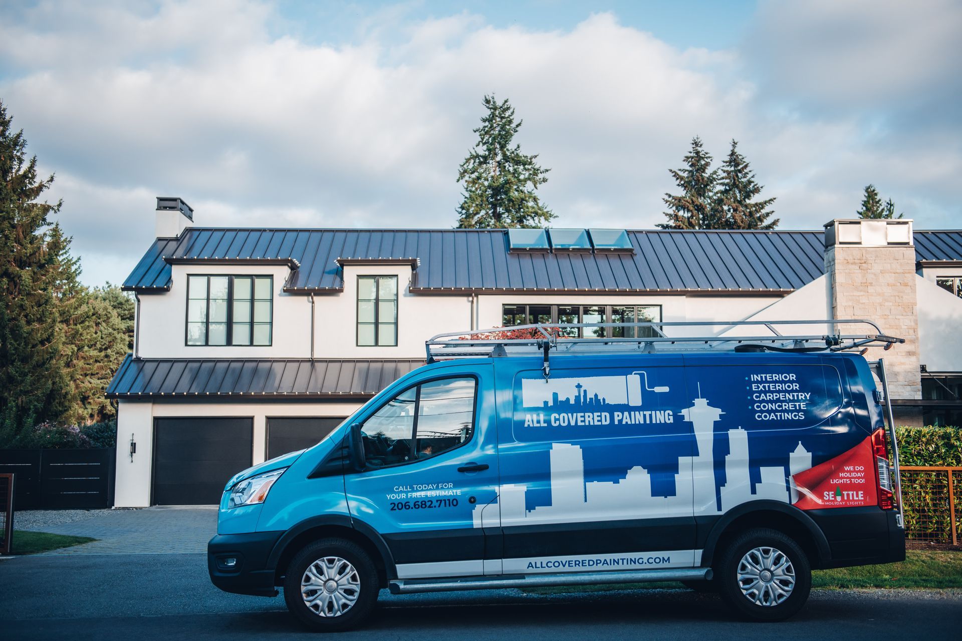 A blue van is parked in front of a house.