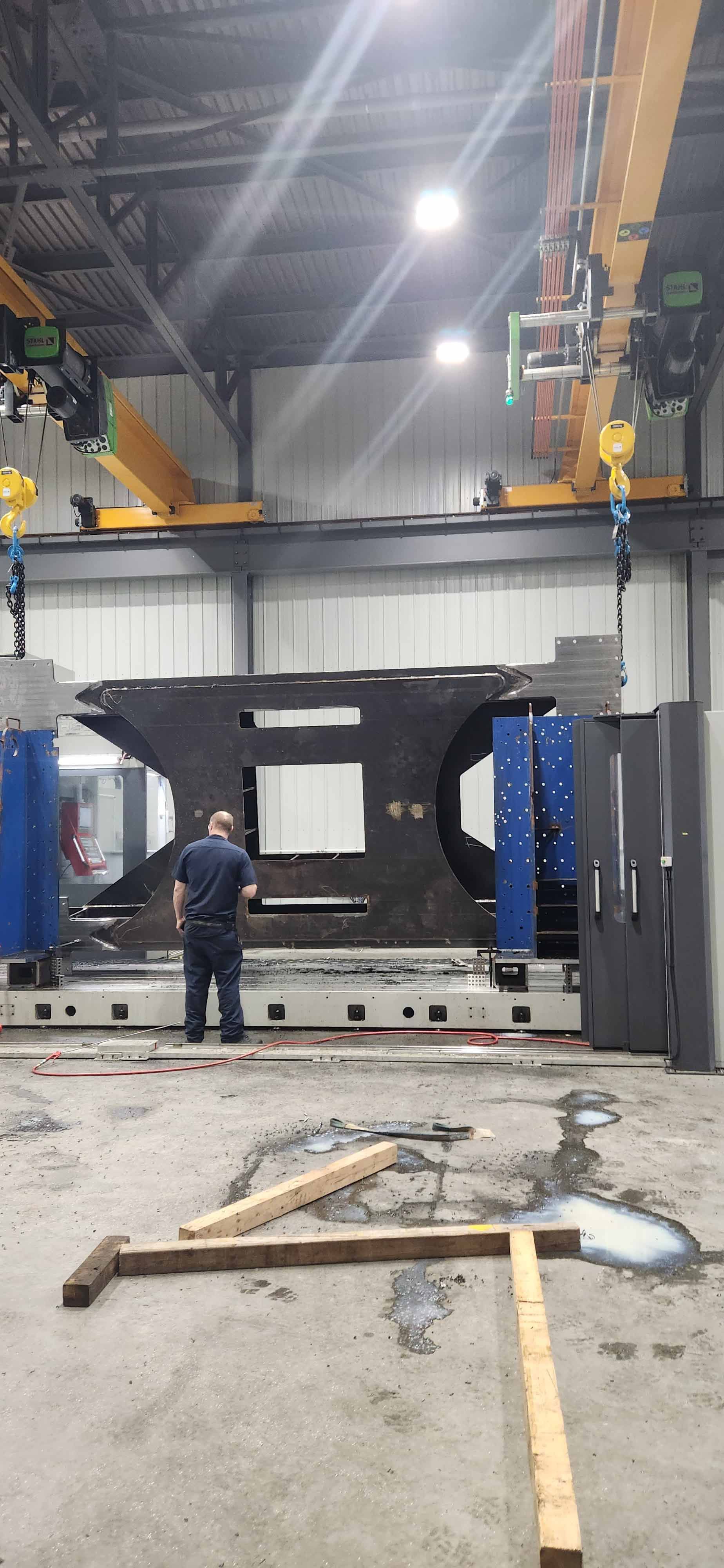 Un homme travaille sur un gros morceau de métal dans une usine.