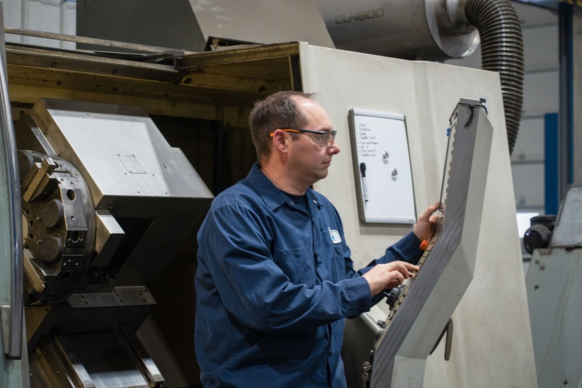 Un homme travaille sur une machine dans une usine.