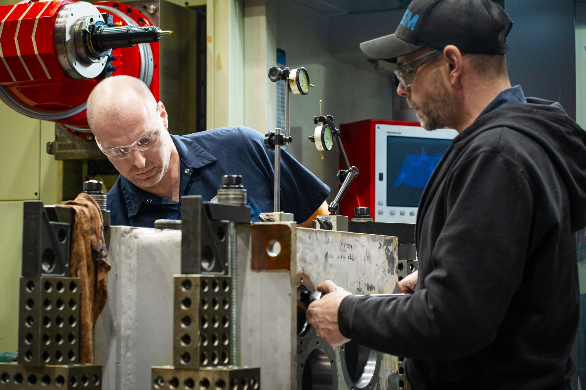 Deux hommes travaillent sur une machine dans une usine.