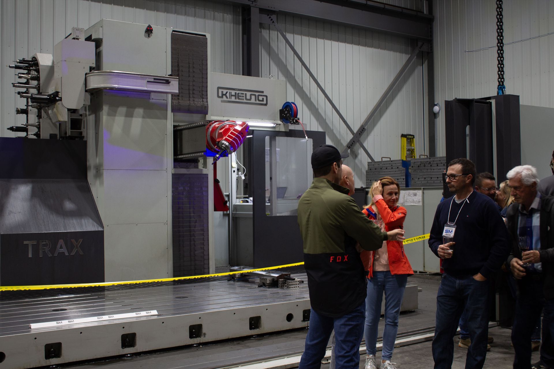 Un groupe de personnes se tient devant une machine dans une usine.