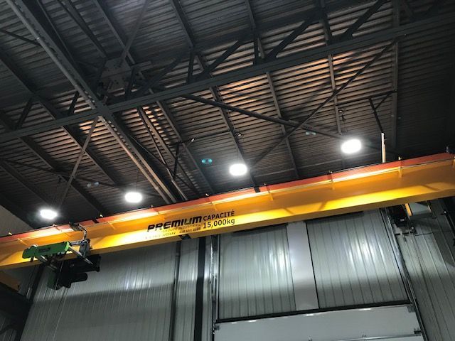 Une grue jaune est suspendue au plafond d'un bâtiment.