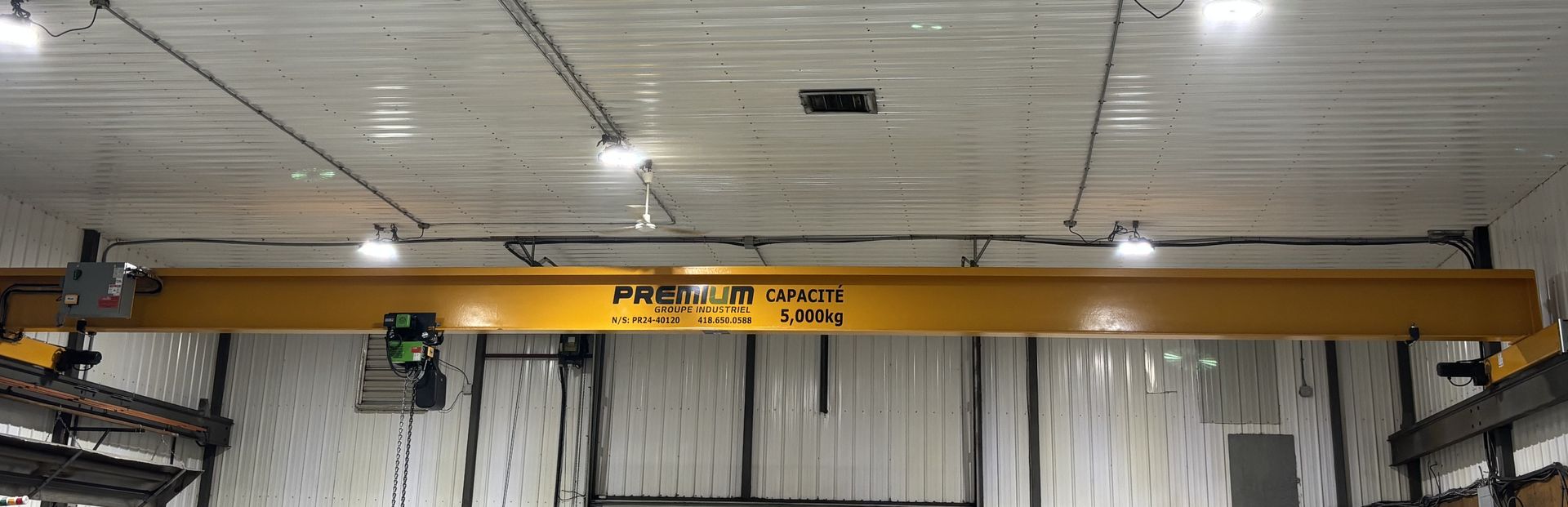 Une grande grue jaune est suspendue au plafond d'un bâtiment.