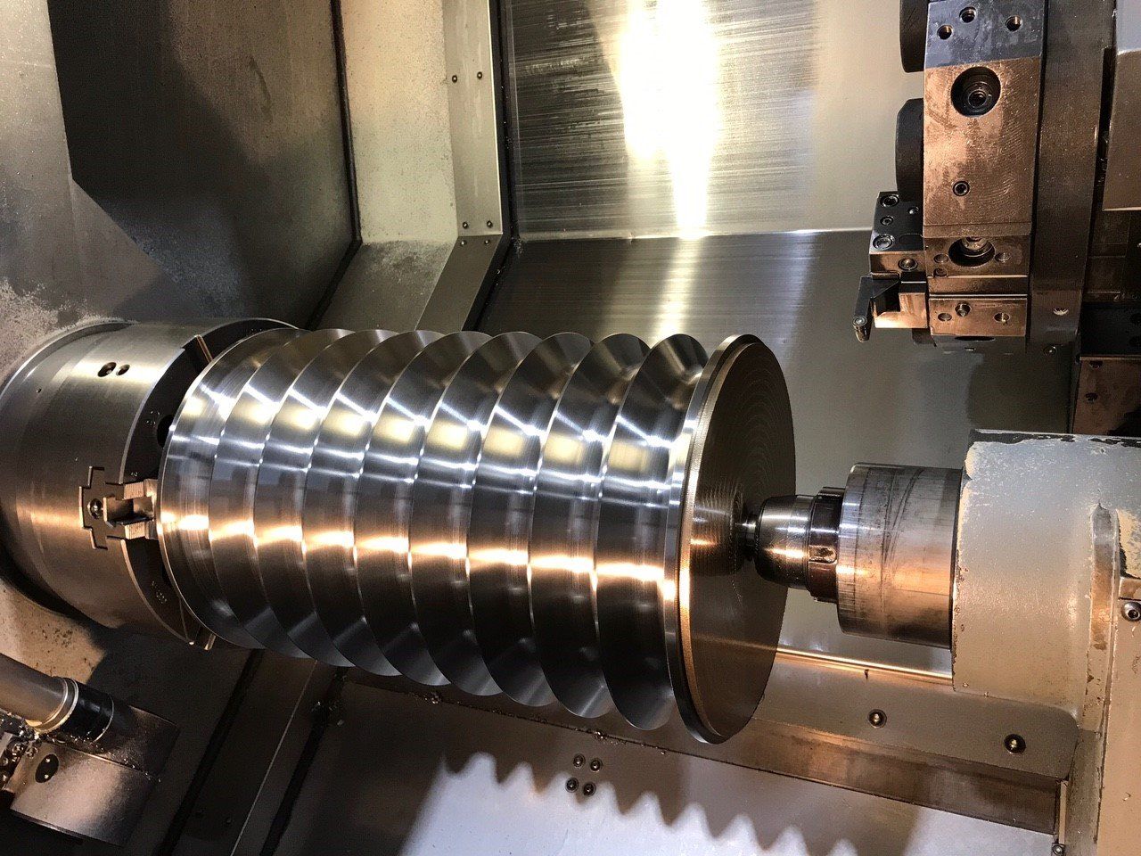 Une machine coupe un objet métallique sur un tour.