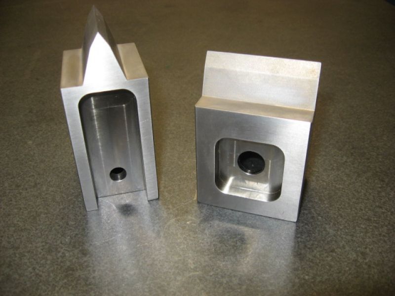 Deux morceaux de métal percés de trous sont posés sur une table