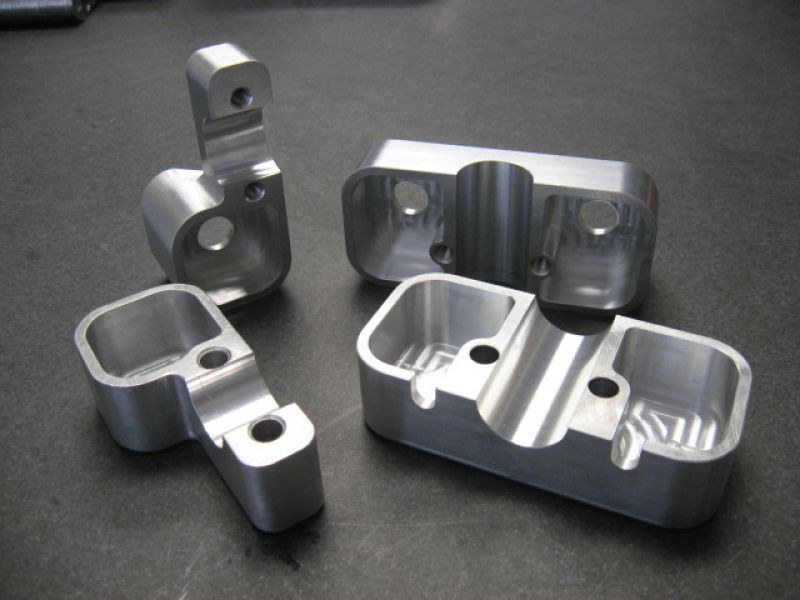 Trois morceaux de métal percés de trous sont posés sur une table