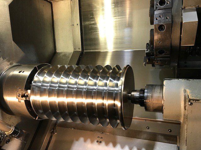 Une machine coupe un morceau de métal sur un tour.