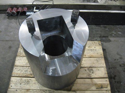 Un gros objet métallique est posé sur une palette en bois