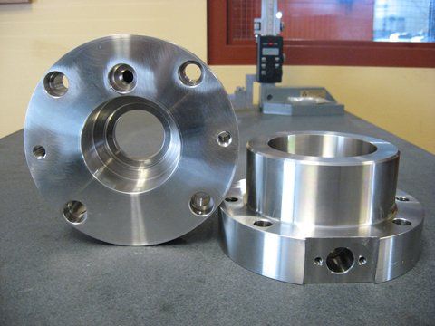 Deux morceaux de métal sont posés sur une table à côté d'un appareil de mesure.