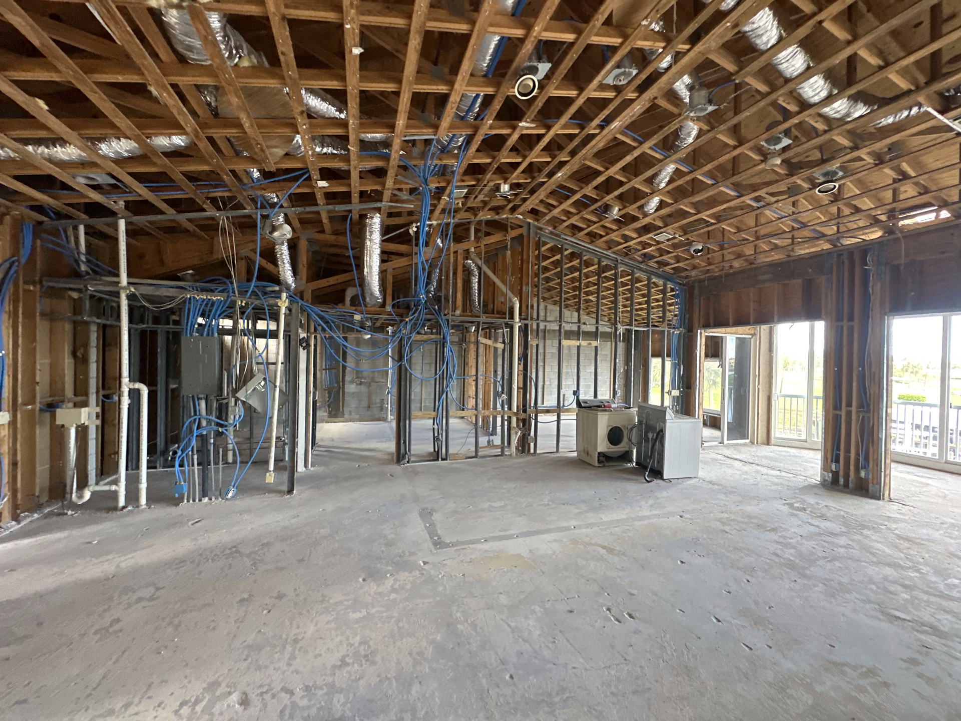 A large empty room with a wooden ceiling in a building under construction.
