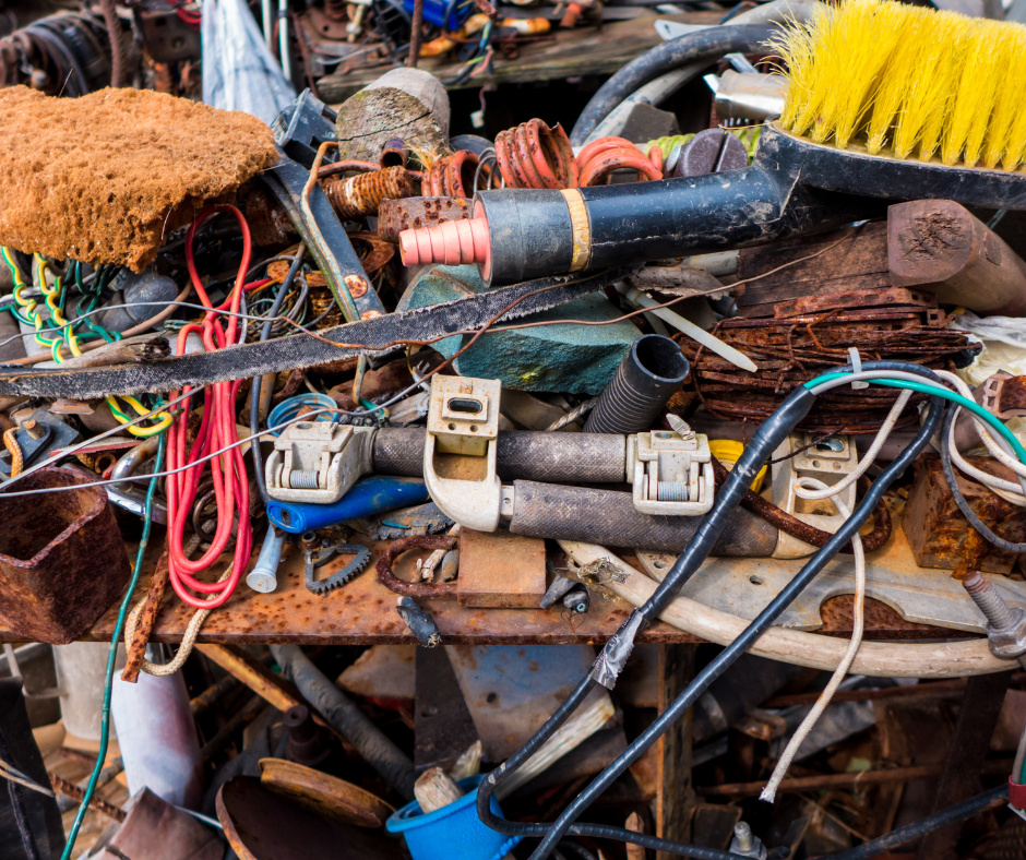 A pile of rusty junk is sitting on top of a wooden table.