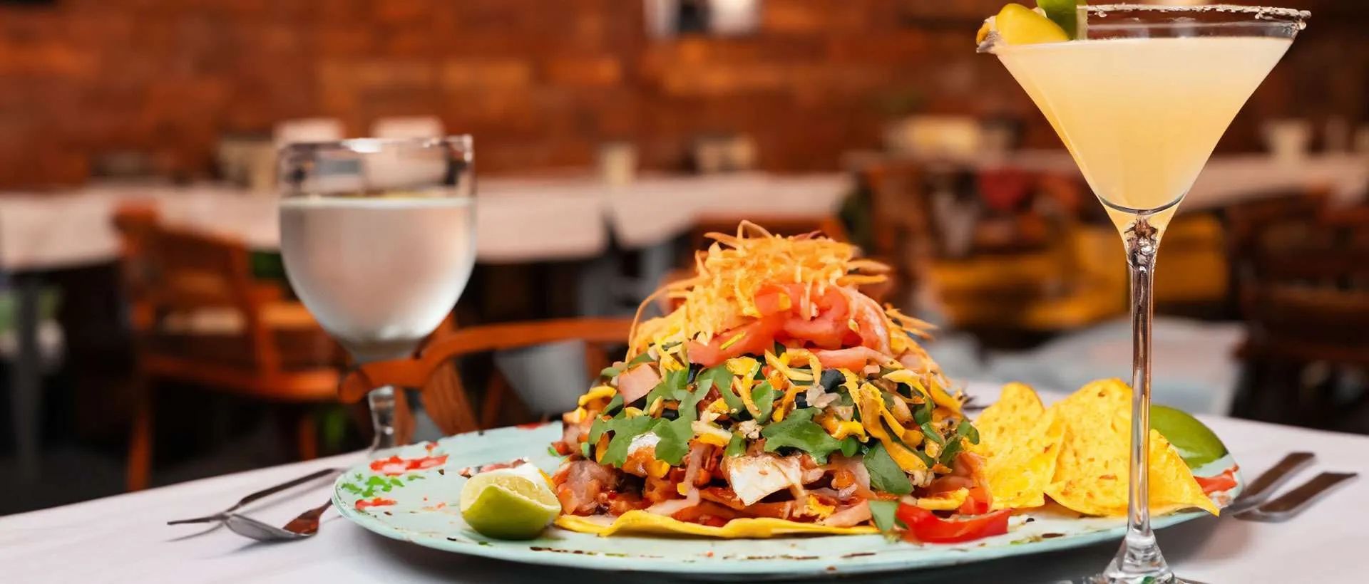 A colorful taco and cocktail on a table in a restaurant.