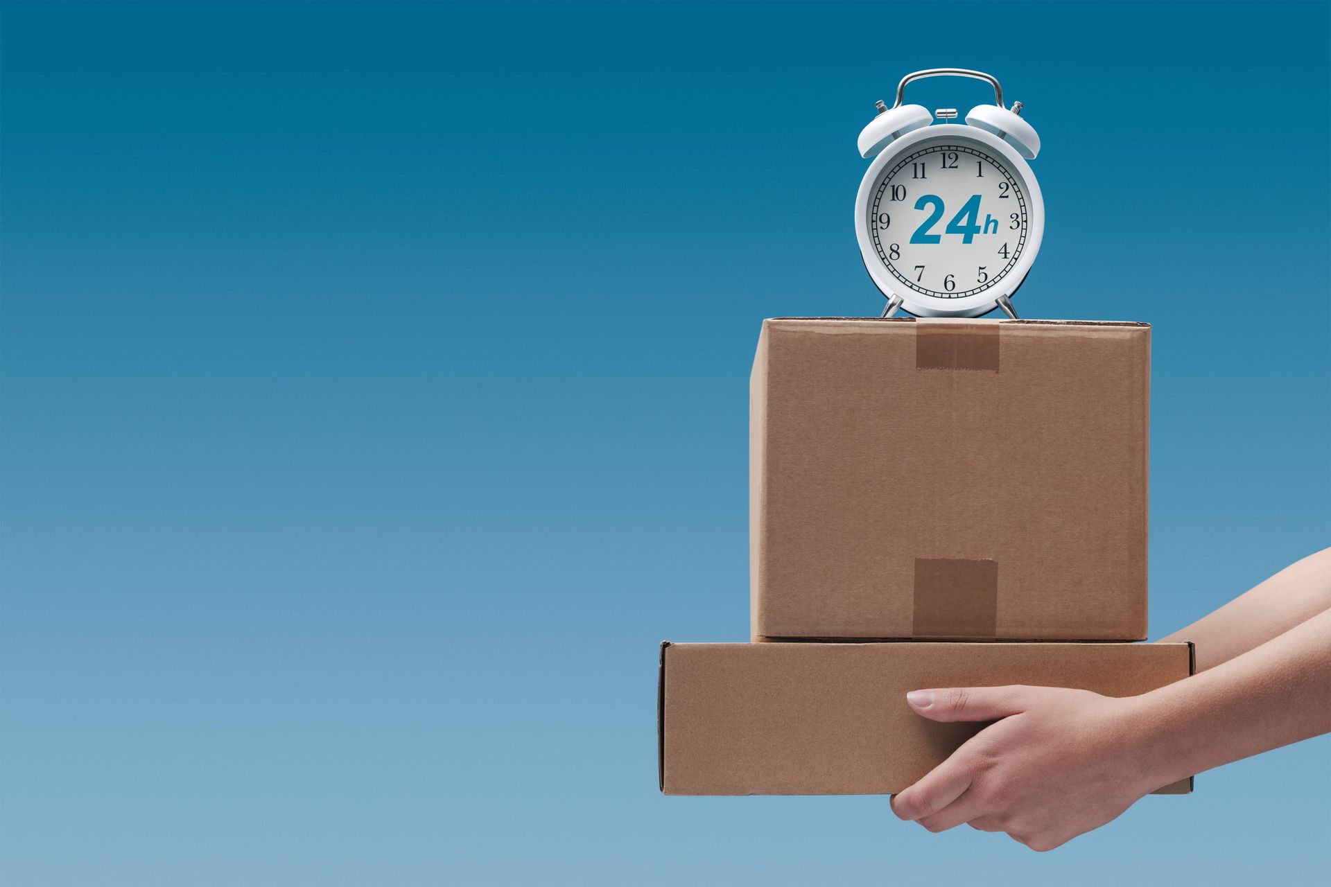 Hands holding a cardboard box with a clock on top against a blue background
