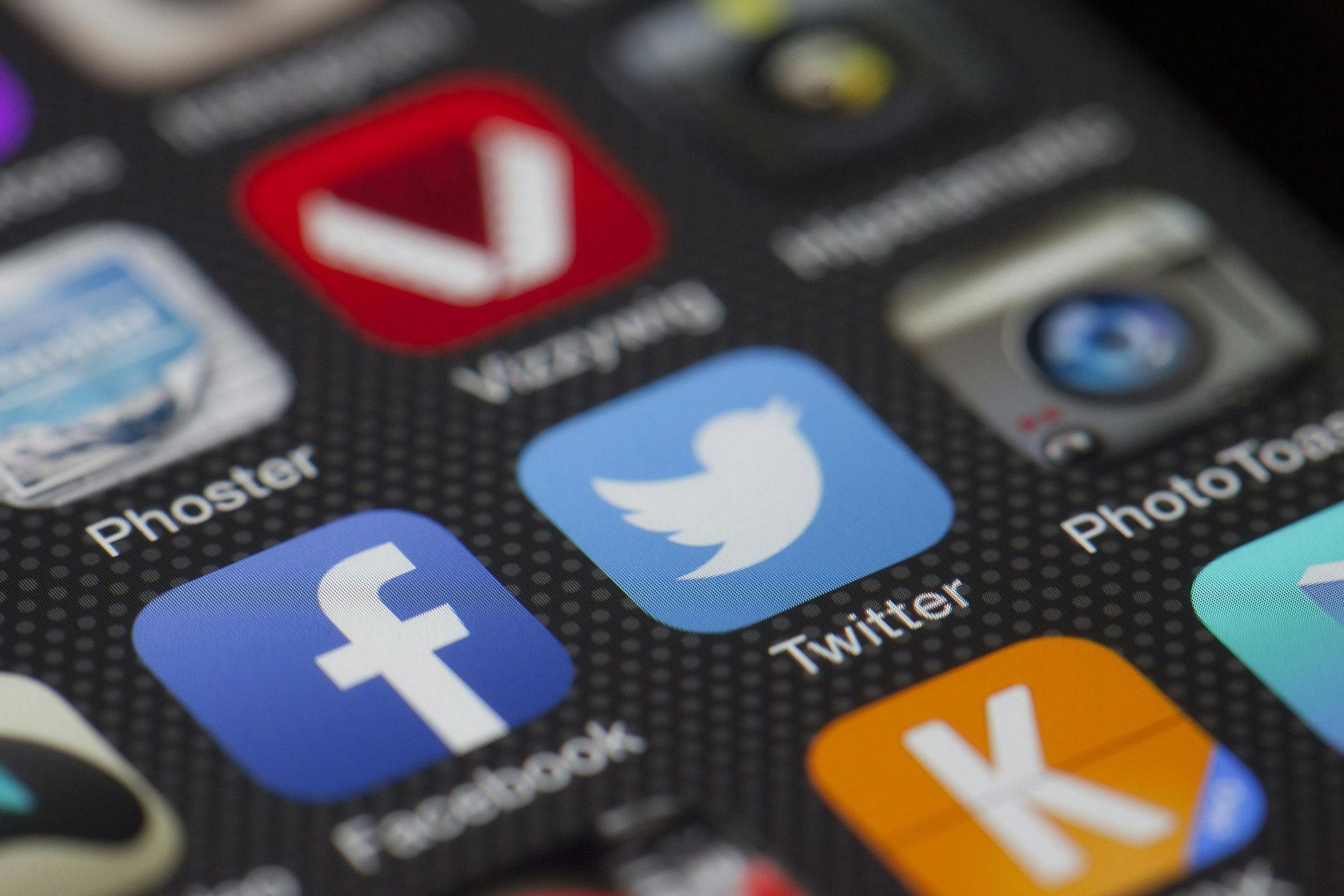 Close-up of a smartphone screen displaying social media app icons: Facebook, Twitter, and others.