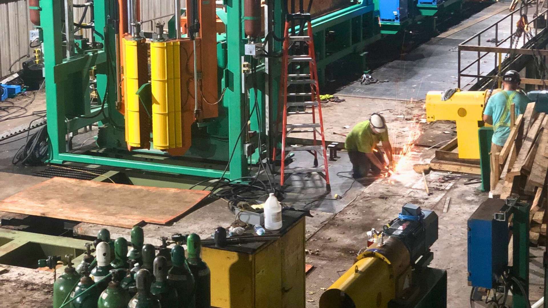 a man is welding a machine in a factory .