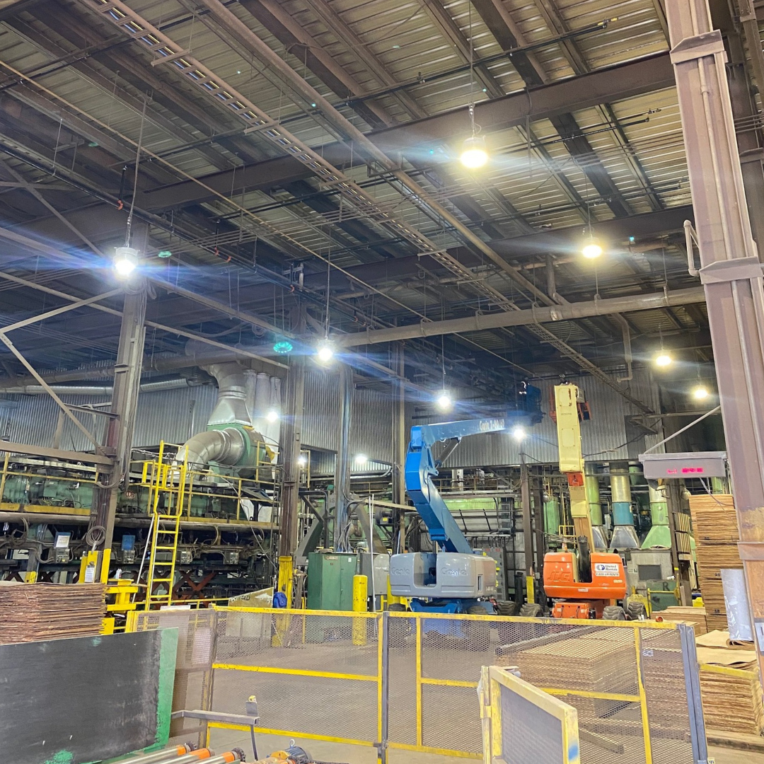 a large warehouse with lots of machinery and a fence