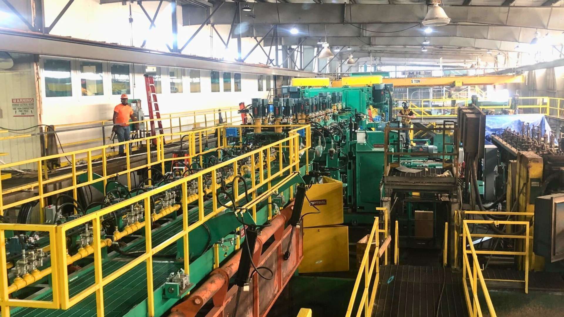 a large warehouse filled with lots of machinery and workers .
