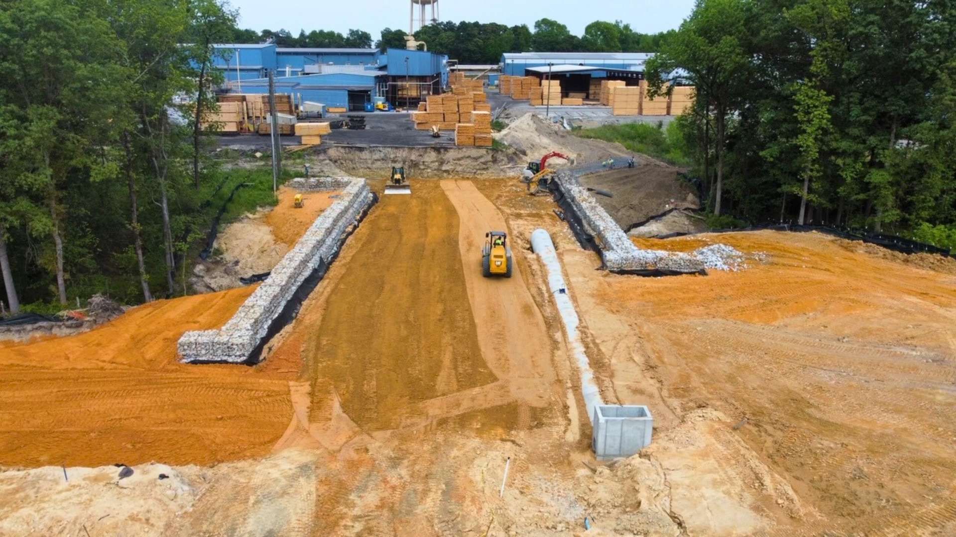 an aerial view of a construction site with a bulldozer driving down a dirt road .