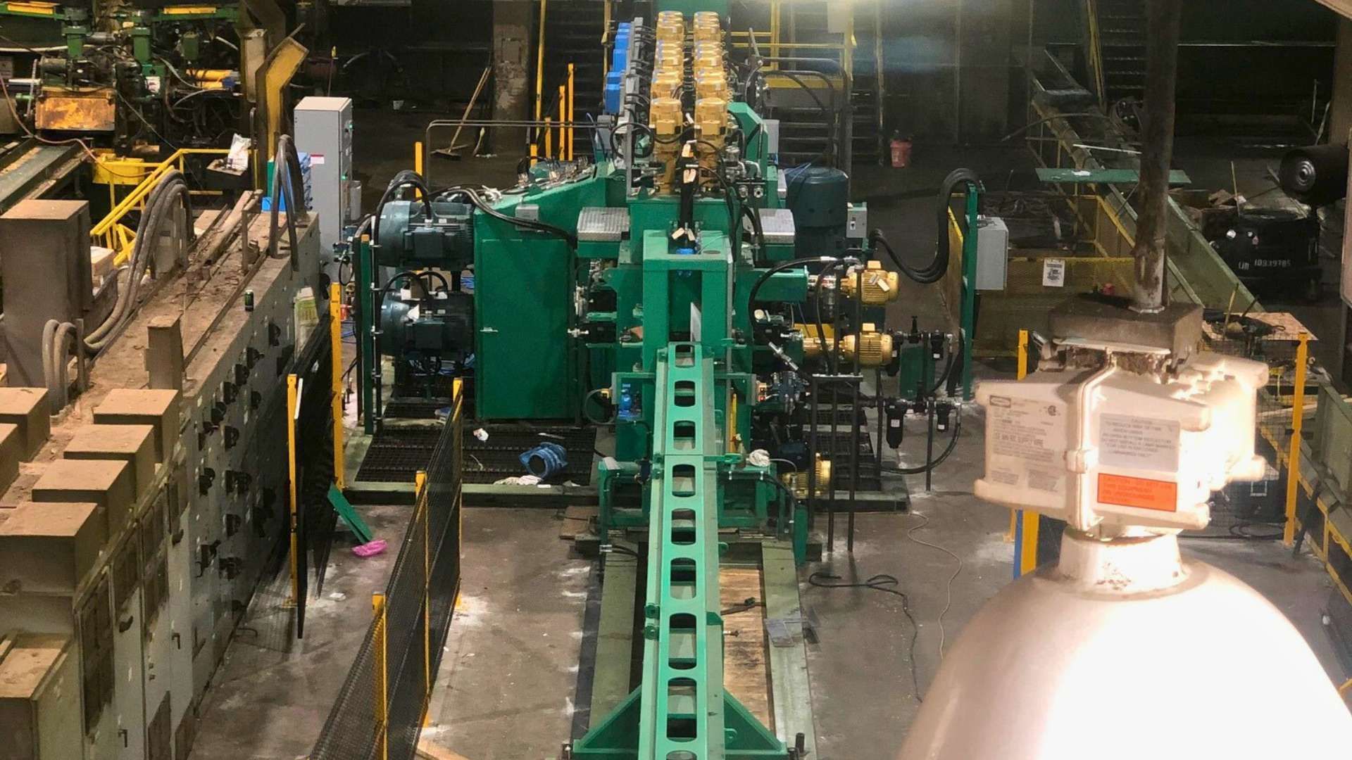 a large green machine is sitting in the middle of a factory .