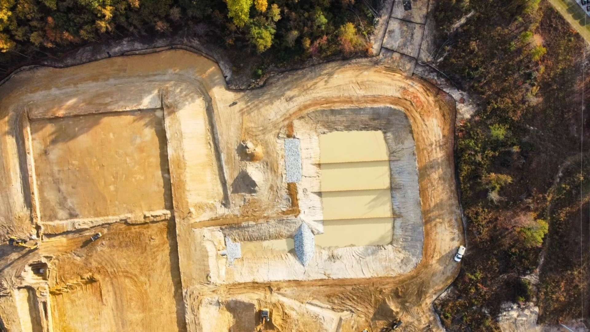 an aerial view of a construction site in the middle of a forest .