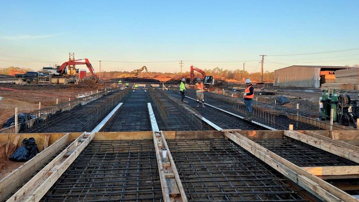 a group of construction workers are working on a bridge under construction .