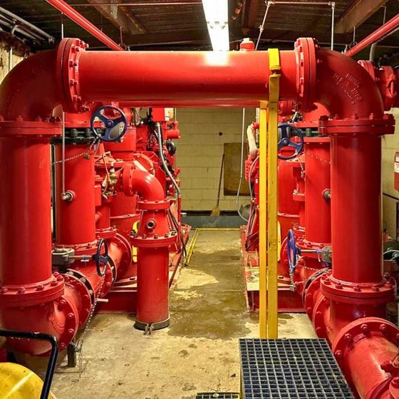 a room filled with lots of red pipes and valves
