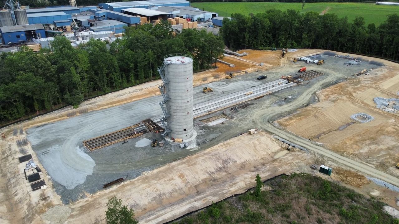 an aerial view of a construction site with a large silo in the middle of it .