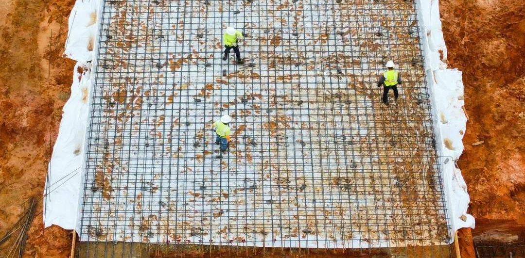 a group of construction workers are working on a concrete slab .