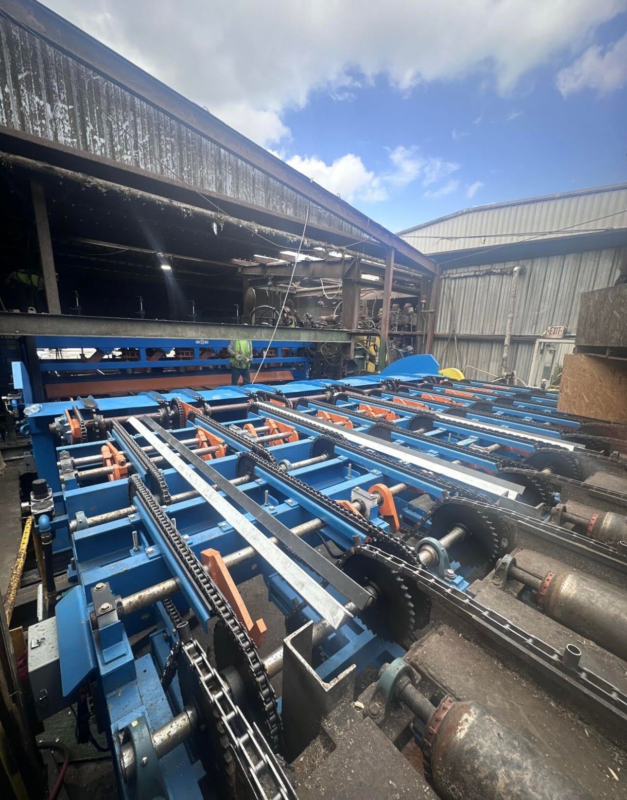 a large green machine is sitting in the middle of a factory .