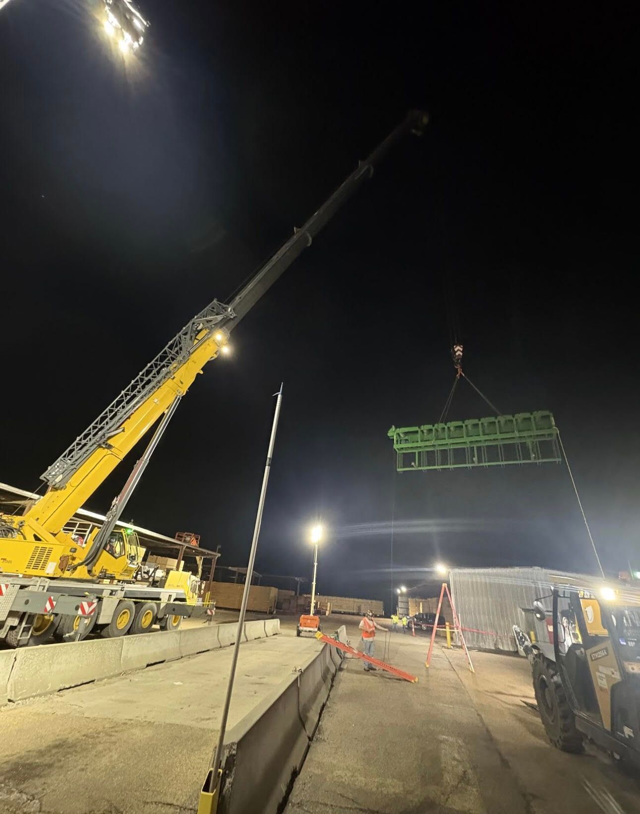 a large warehouse filled with lots of machinery and workers .