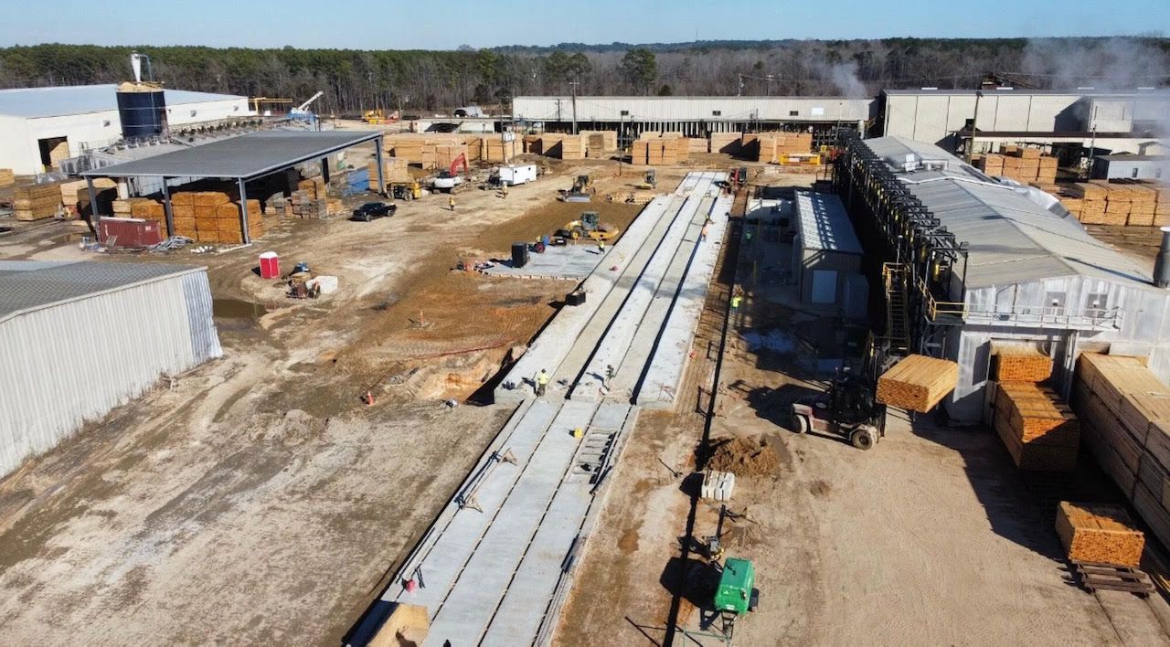 a large green machine is sitting in the middle of a factory .