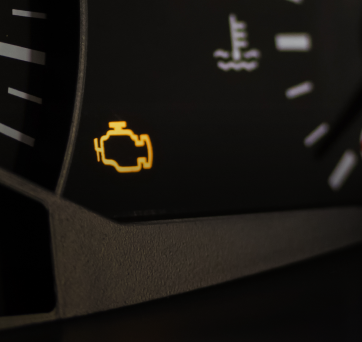 A close up of a car dashboard with a yellow engine light on it | DAS Auto Werks