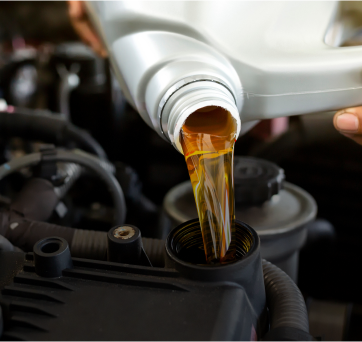 A person is pouring oil into a car engine | DAS Auto Werks