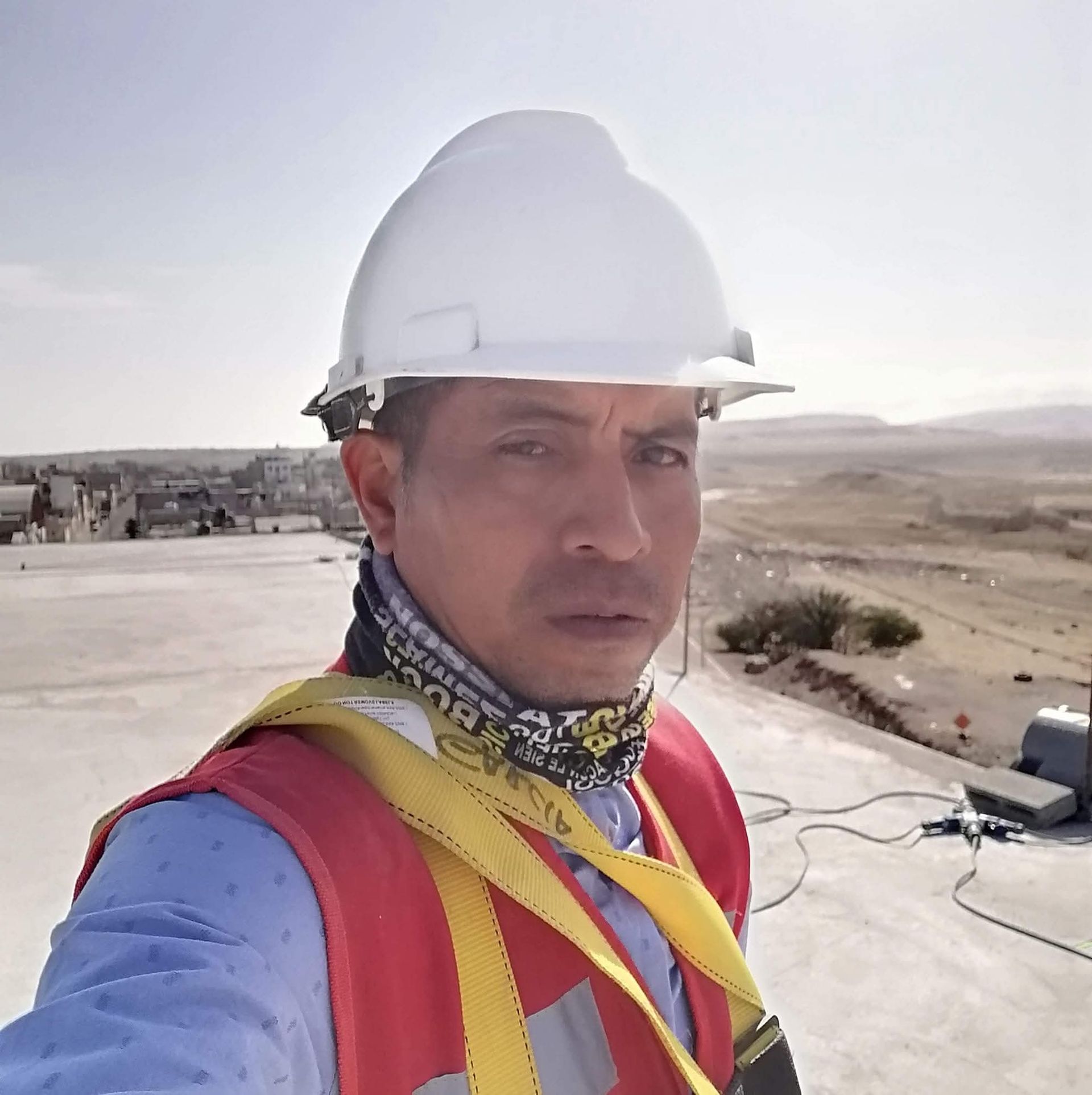 Trabajador de la construcción utilizando equipo de topografía cerca de la costa.